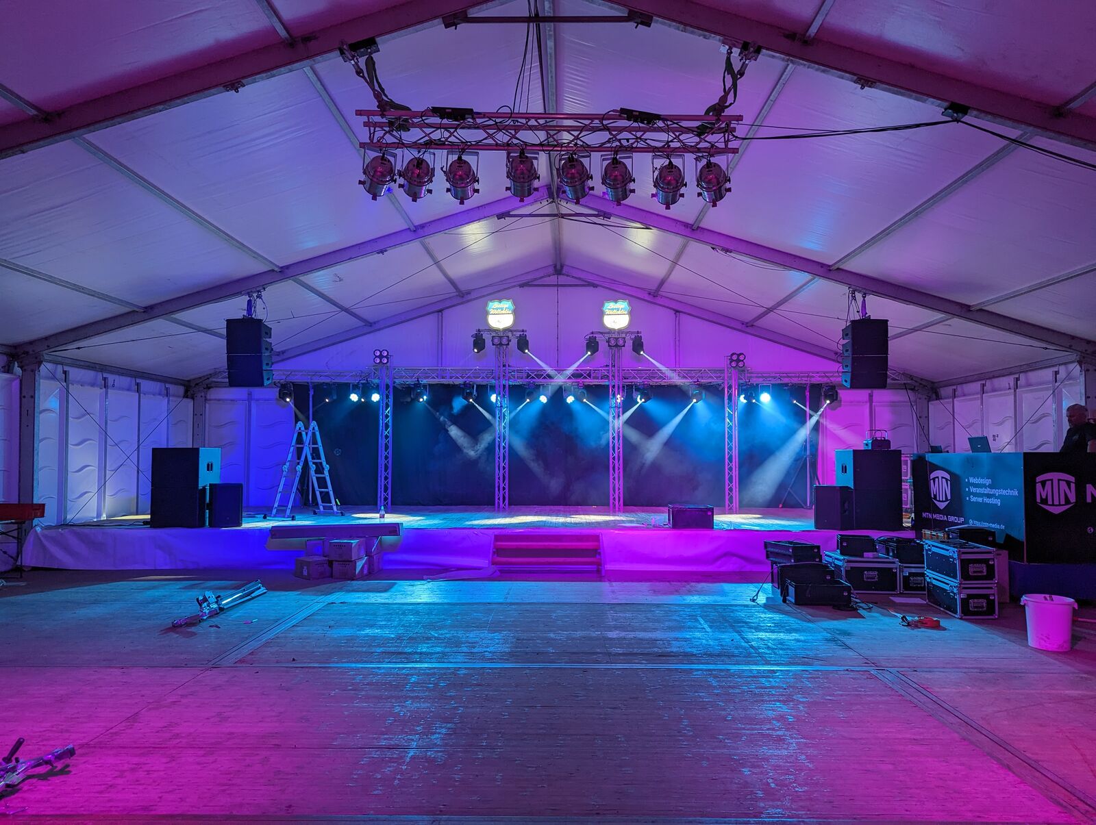 Stage build in blue light with truss towers before doors open