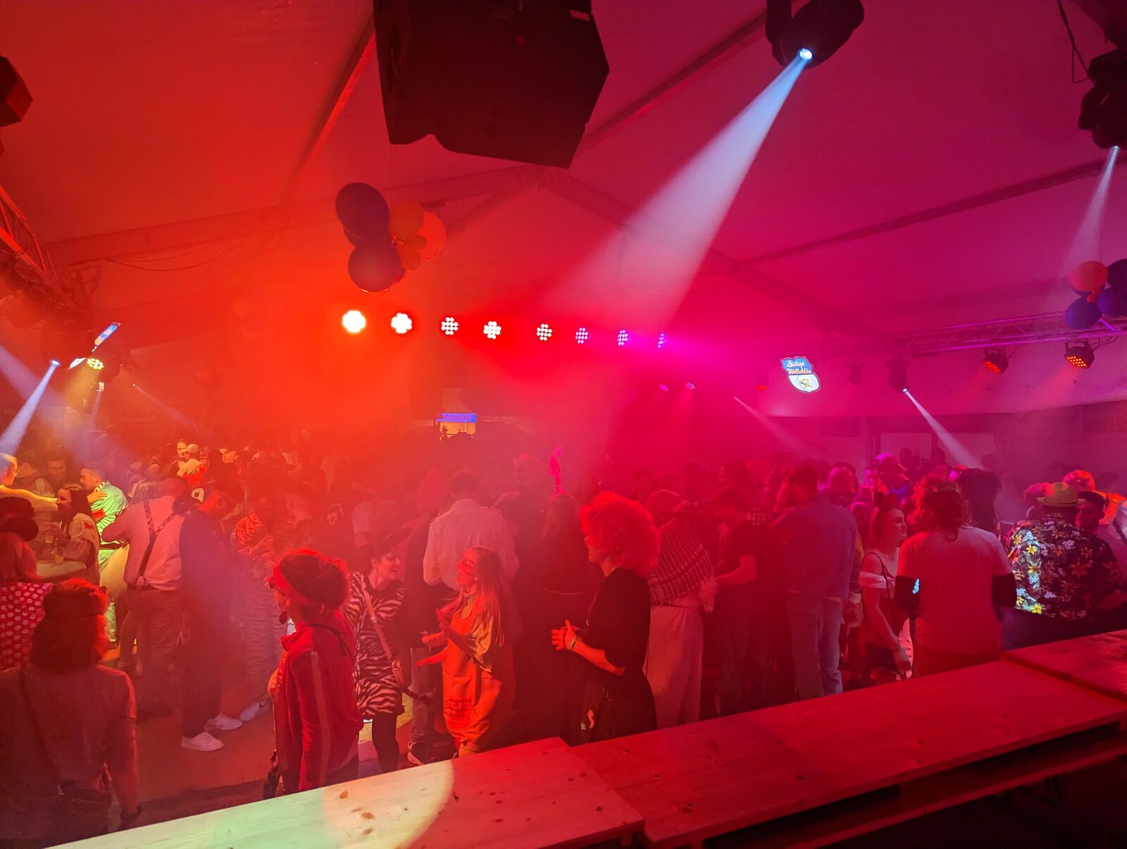 Crowd in a deep red lighting wash with spot beams