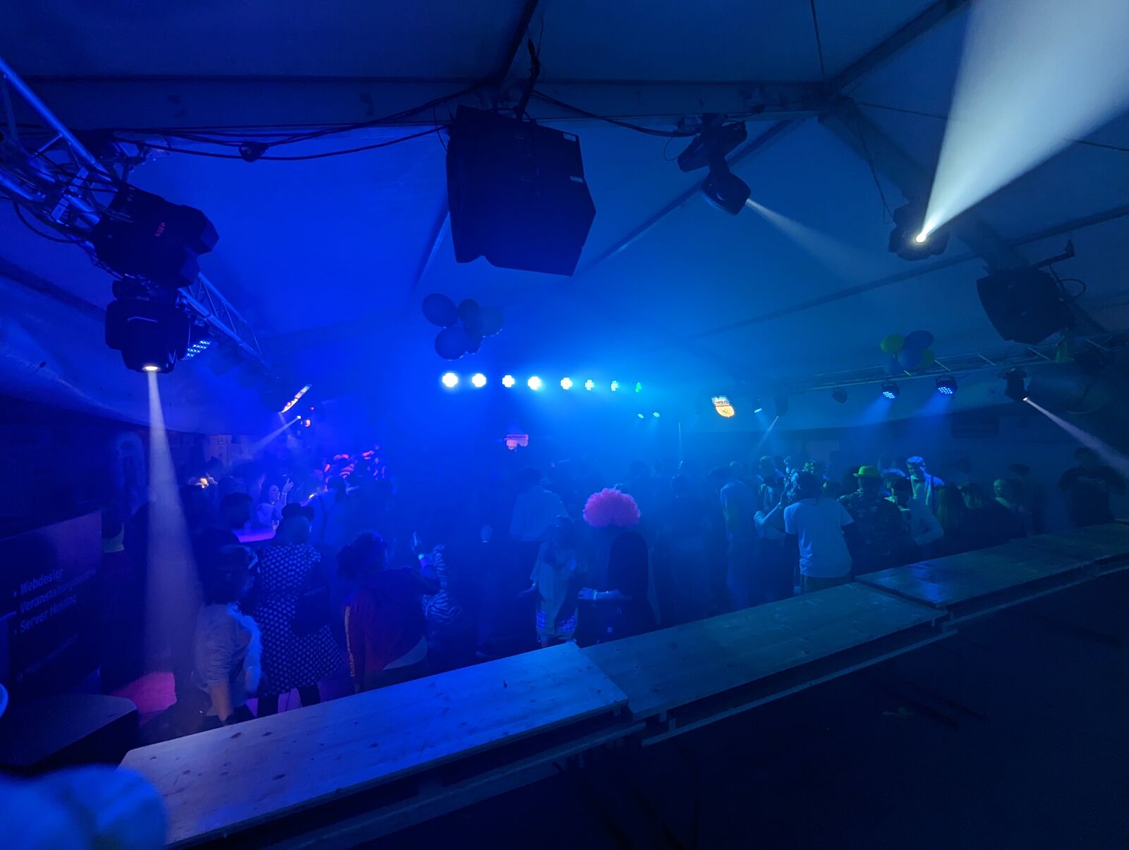 Blue beams and moving heads cutting through the haze