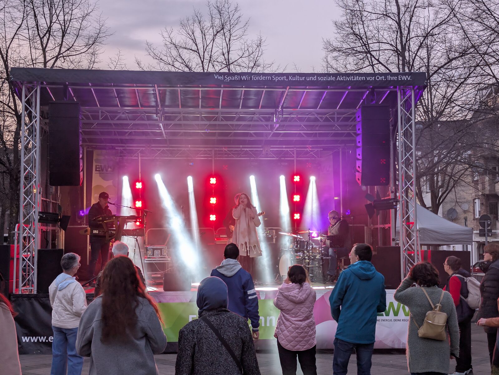 Mobile open-air stage with band, beam looks and PA on the stage wings